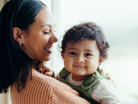 woman smiling while holding a baby