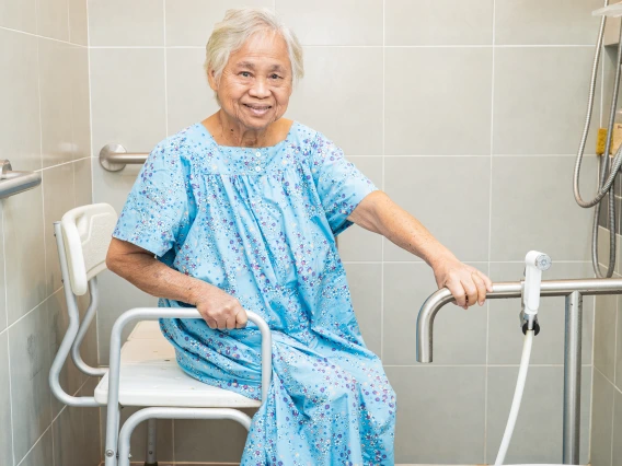 woman in shower with chair and hand rails
