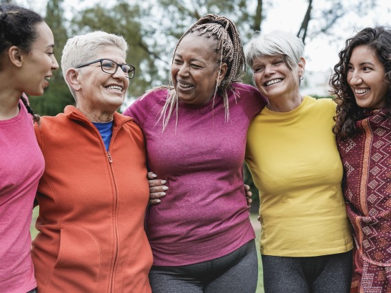 Five women embracing in colorful shirts