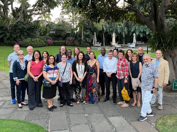 Dean Hamkim and Dr. Valdez with a large group of conference members, outdoors in a park