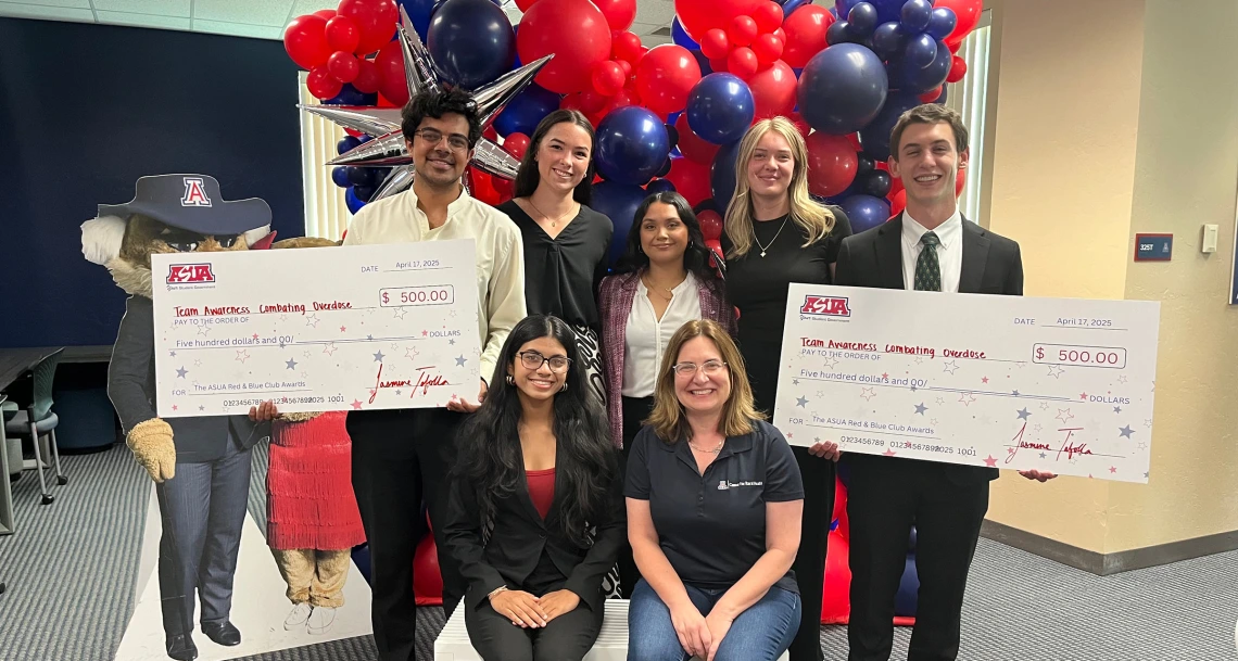 TACO student group holding two award winning checks