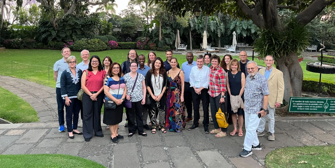 Dean Hamkim and Dr. Valdez with a large group of conference members, outdoors in a park