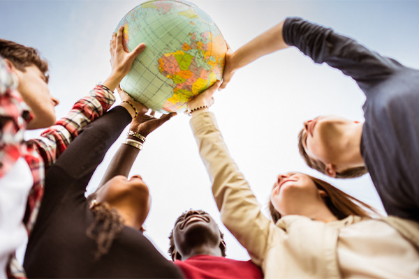 Students holding up a world globe