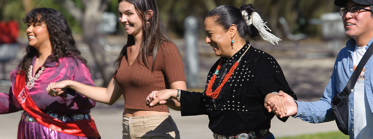  Students and alumni in a traditional native american round dance