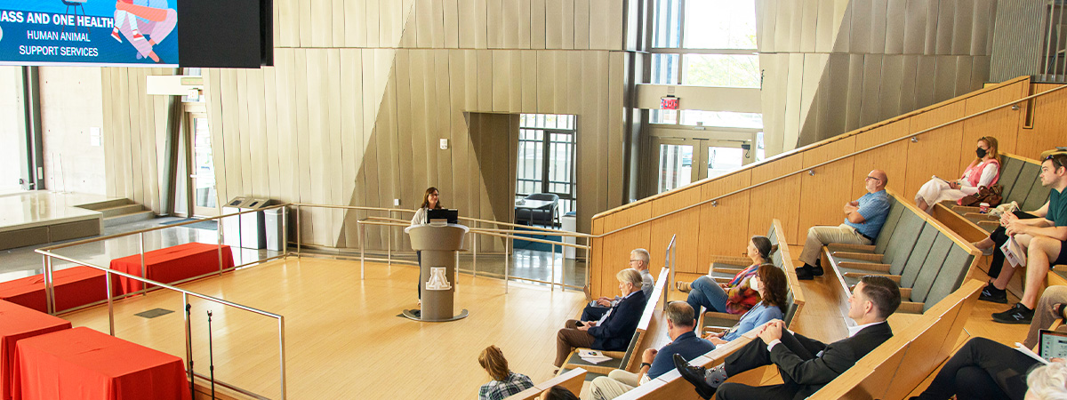 Phot of hall with symposium crowd and Dean Hakim at podium