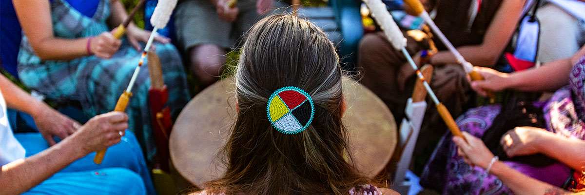  woman wearing native headband in a drum circle