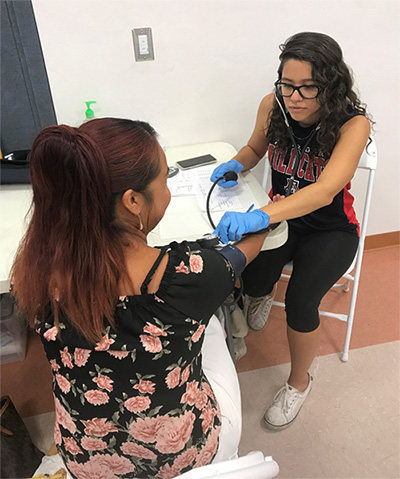 Camille Gonzalez, a UA public health graduate student, takes the blood pressure of a client at Our Lady of Fatima Parish in Tucson on July 2. Gonzalez and the mobile unit team provided health screenings to 70 Pima County residents from Guanajuato, Mexico, at the church over that weekend.